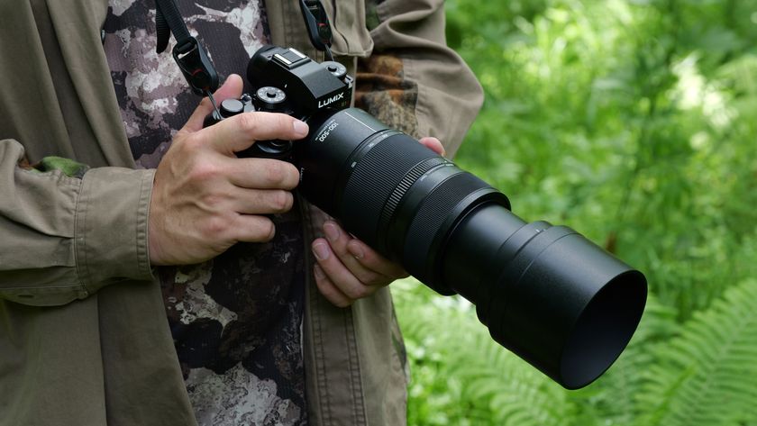 Panasonic Lumix S 100-500mm f/5-7.1 lens attached to a camera held in a photographer&#039;s hands