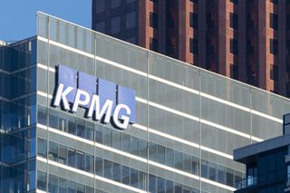 A photo of a grey building with the KPMG logo displayed on the side