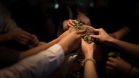 a group of people holds up shot glasses