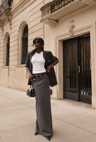 a photo of a woman's classic outfit with a blazer over a tank top with a gray maxi skirt and pointed pumps