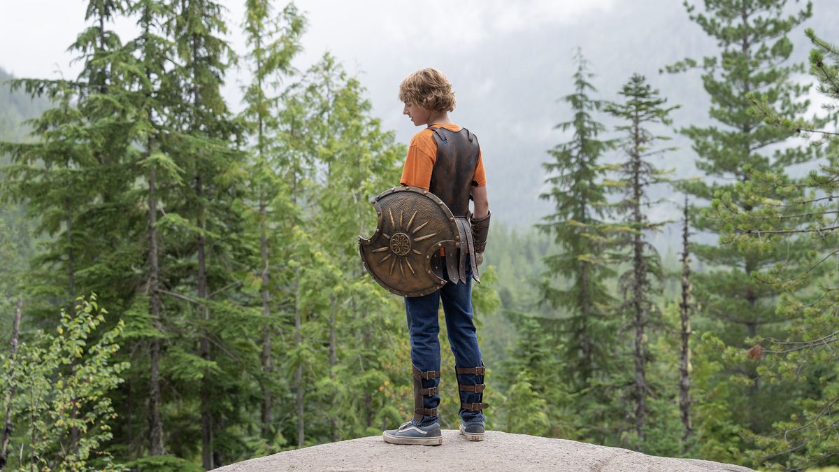 Percy Jackson (Walker Scobell) facing away from the camera over a forest in Percy Jackson and The Olympians