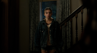 Sydney Sweeney stands in a darkened hallway in Echo Valley