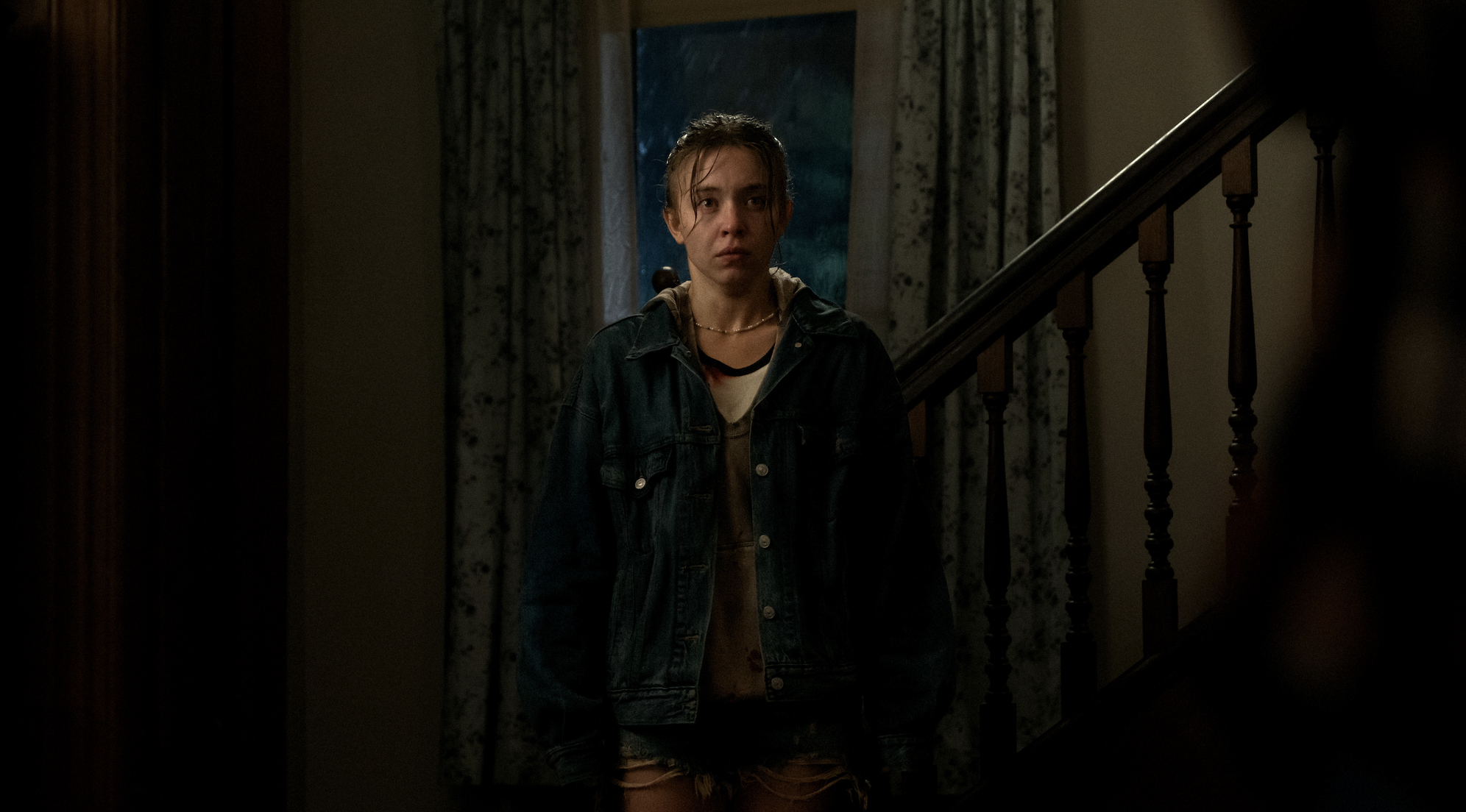 Sydney Sweeney stands in a darkened hallway in Echo Valley