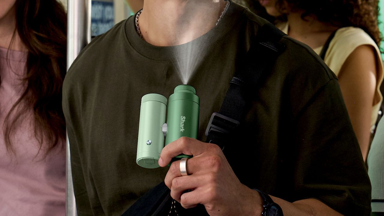 Man using Shark ChillPill personal misting fan on public transport