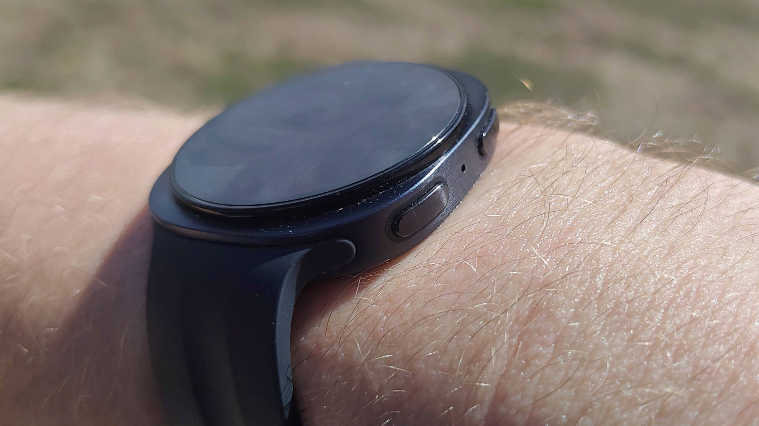 The Samsung Galaxy Watch 9 on a man's wrist, showing the side buttons.