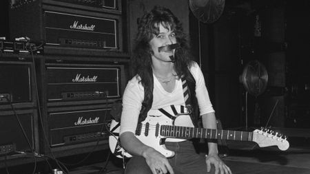 Eddie Van Halen holding his guitar in front of a stack of Marshall amps, 1978.