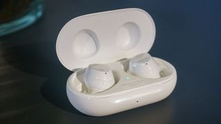 A pair of the Samsung Galaxy Buds Plus in white in their charging case.