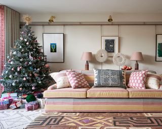 Modern living room with large striped sofa and cushions, christmas tree, geometric rugs