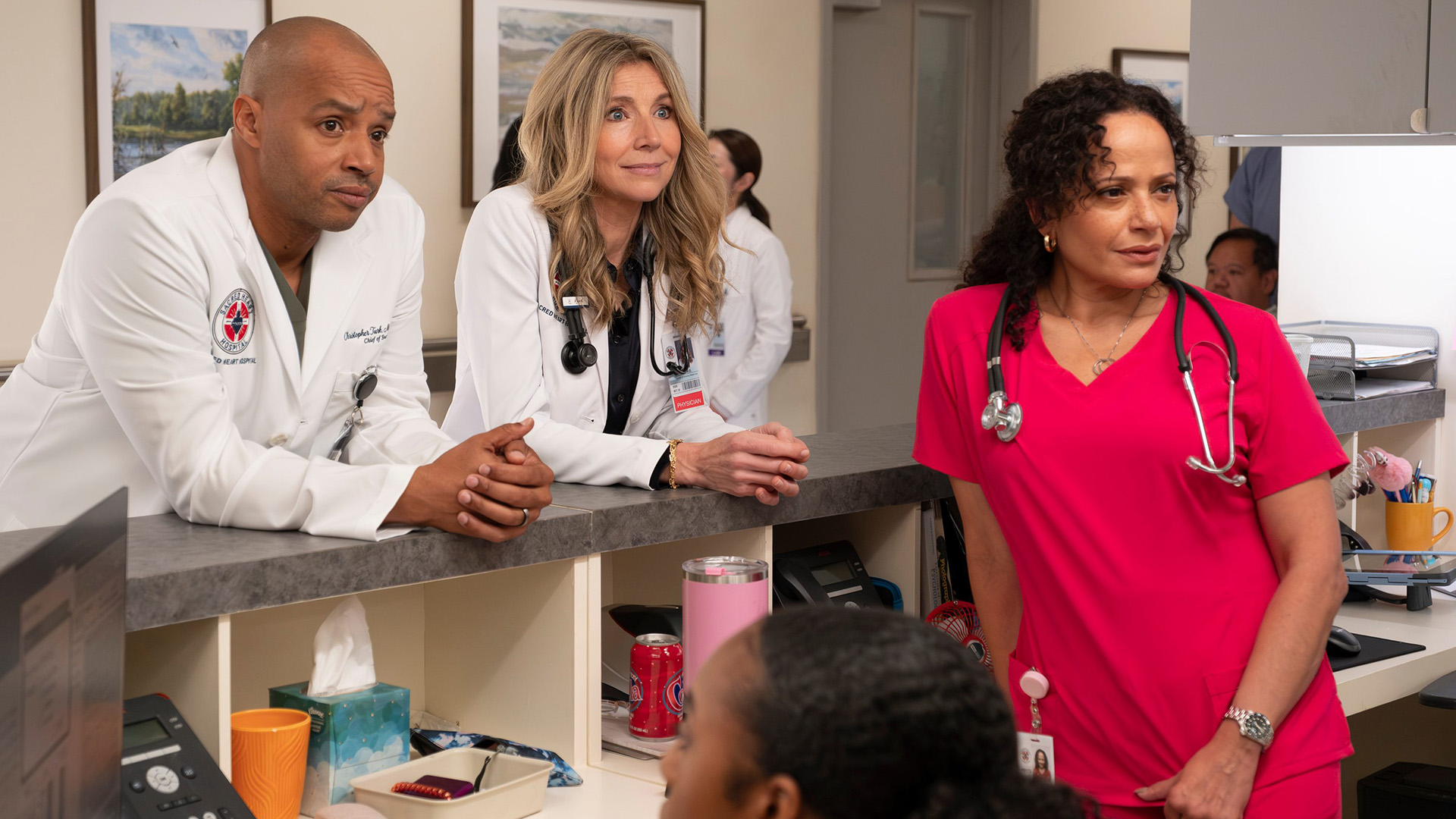 Turk and Elliot leaning on a front desk behind Carla in the Scrubs revival