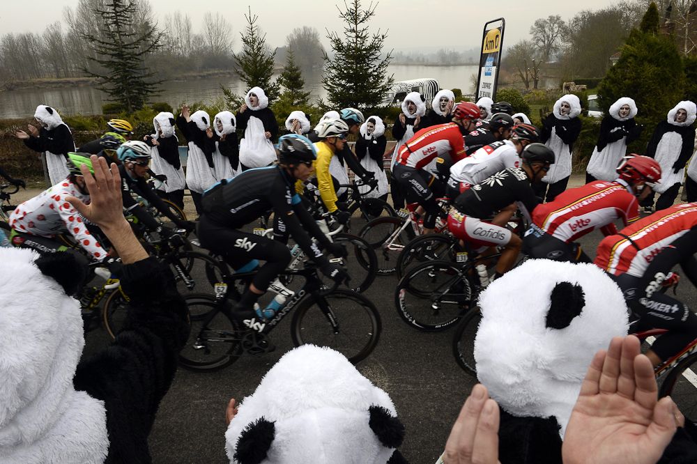 Michal Kwiatkowski wearing the overall leader's yellow jersey rides in the pack as cyclists take the start of the second stage of Paris-Nice.