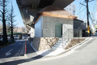 marc newson's contribution to the tokyo toilet project is a concrete structure under a bridge