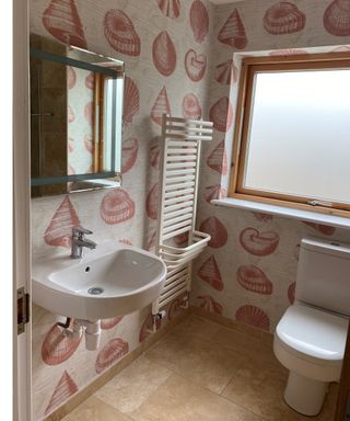Beige and coral seashell printed wallpaper design in bathroom by Elizabeth Ockford