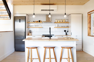 A minimalist kitchen with pale butcher block countertop