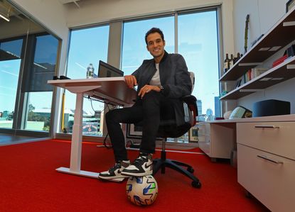 Will Ahmed sits in an office with his foot on a soccer ball