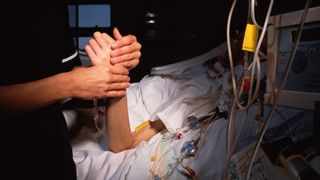 Nurse checks patient's pulse.