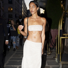 Laura Harrier wears a sparkly bandeau top, matching thong heels and the awkward midi skirt trend in Paris in an image taken on the 28th of June 2025. 