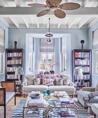 living room with bookshelves, couch and ceiling fan