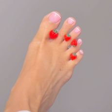 A close-up of a foot, with the toenails painted with a pink french pedicure shade