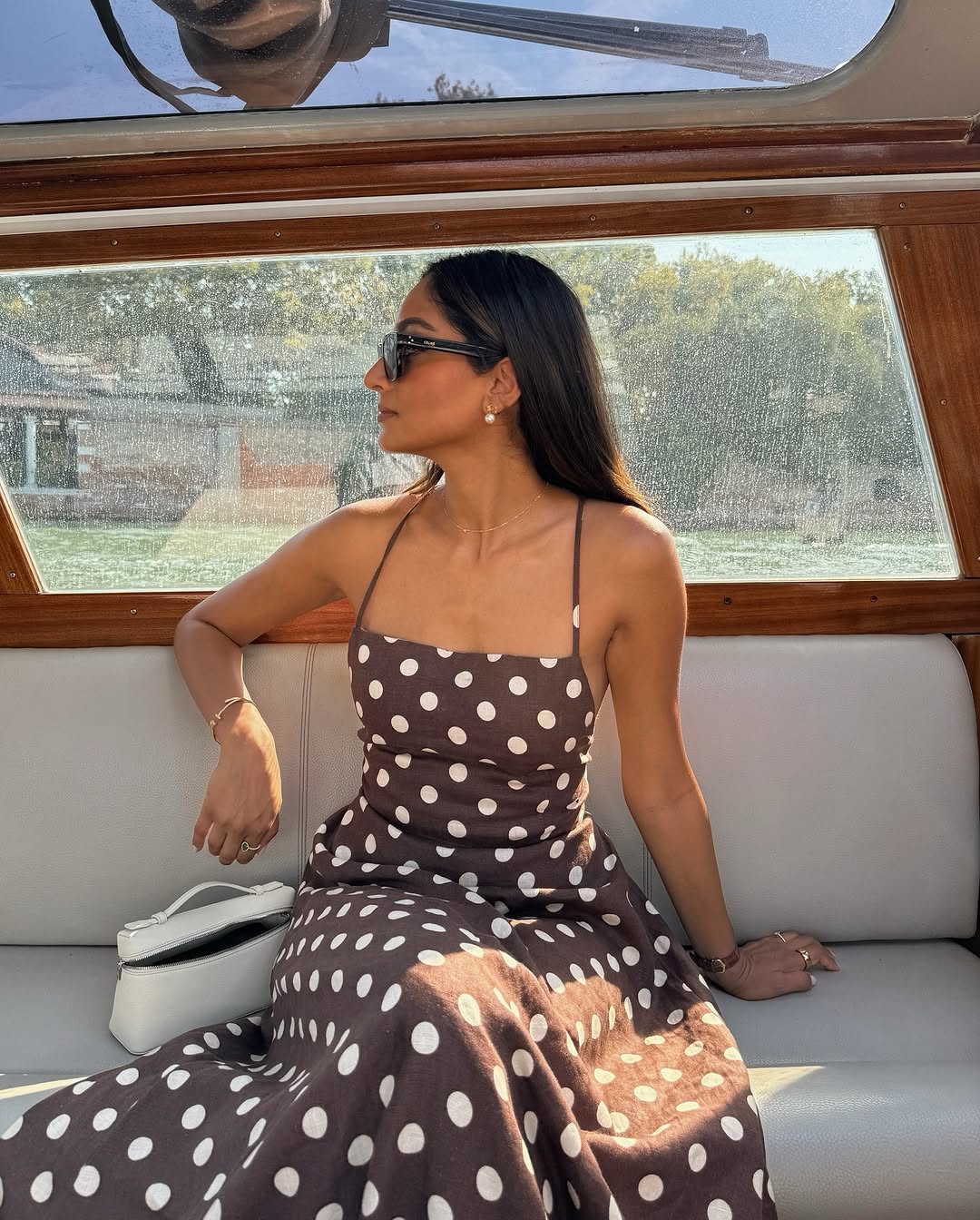Influencer Coco Beautea in a brown and white polka dot halter neck dress.