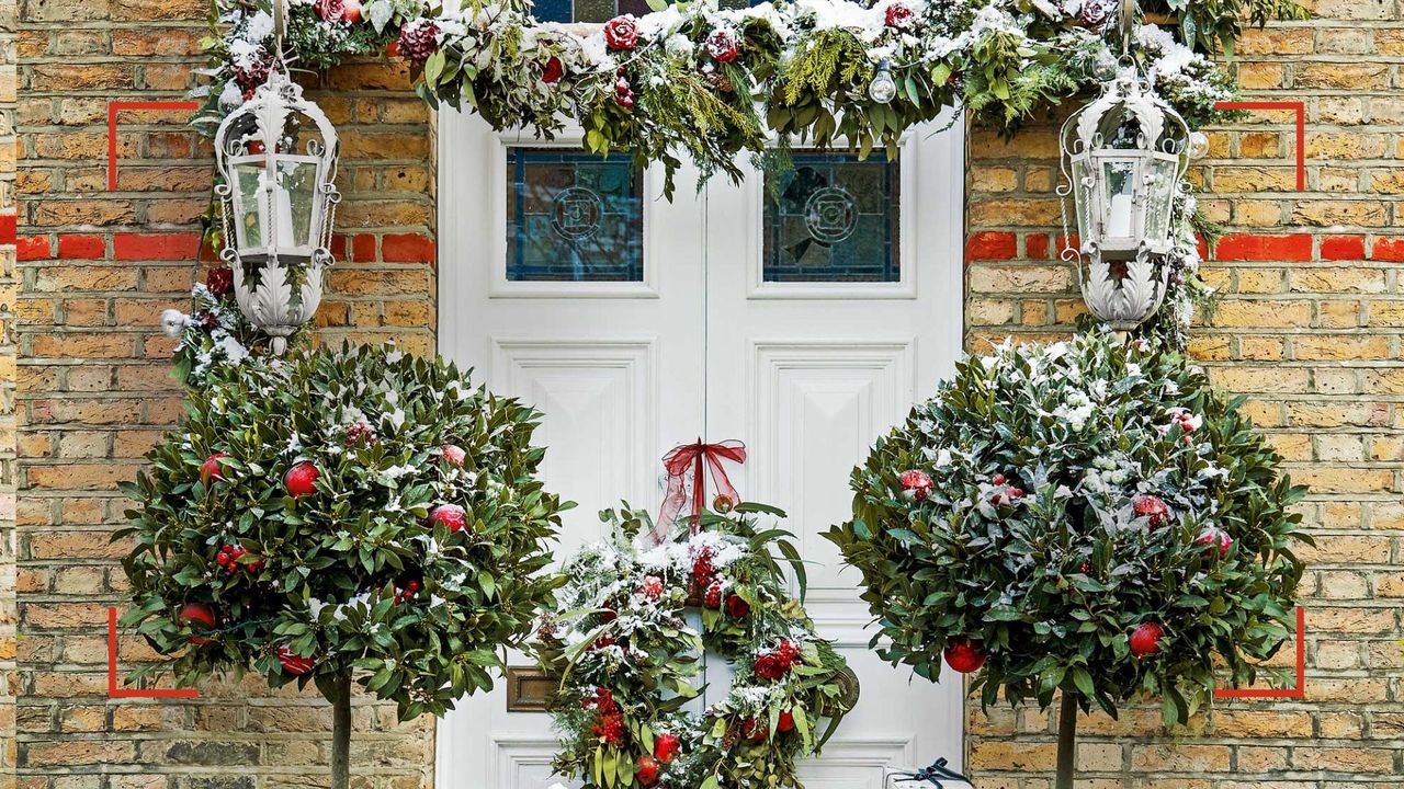 House exterior with Christmas garland and matching bay trees either side of the door to show the Curtain pole Christmas decoration trend