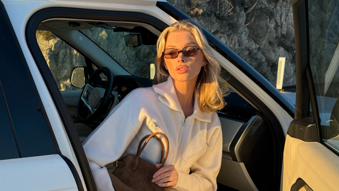 Elsa Hosk wearing crew sweaters, white leggings, and The Row bag and shoes