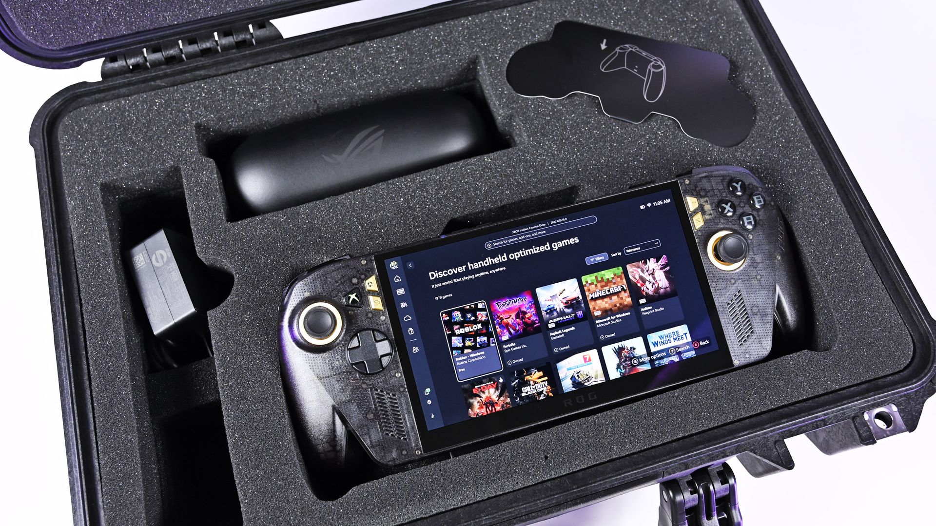 Open Pelican case with custom foam holding the powered-on ROG Ally X20 handheld, 68W charger, and AR glasses case.