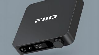 FiiO K11 in black, suspended in mid-air on a gray background