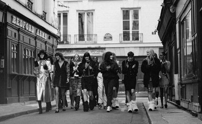 Black and white photo of models walking on a street