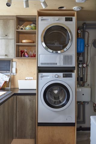 stacked washing machine and tumble dryer in laundry utility room
