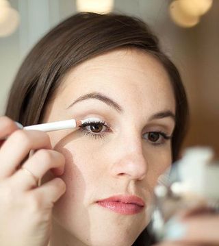 Woman Putting White Liner on Eyelid