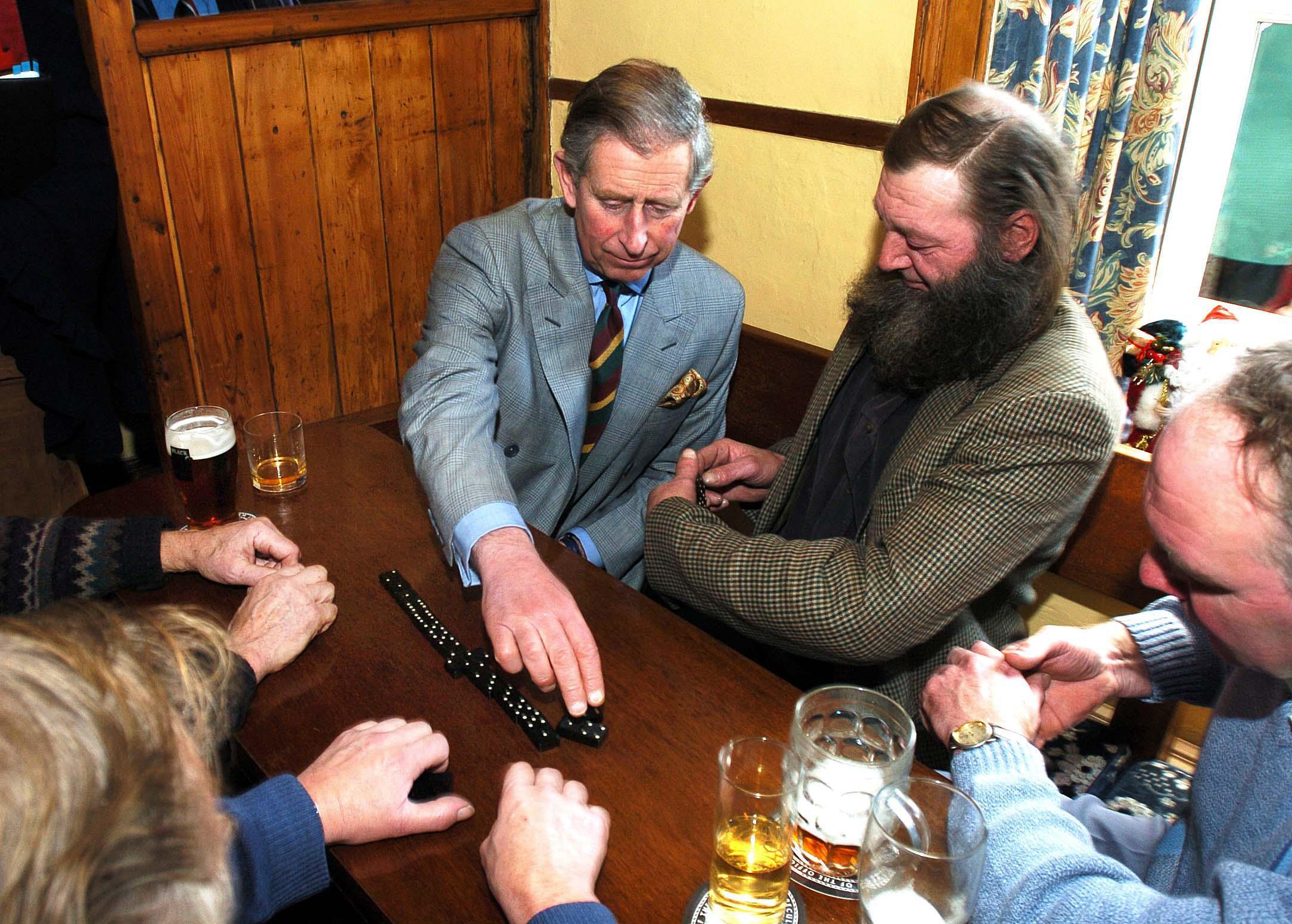G7F1CR The Prince of Wales plays dominoes in the Farmers Arms Pub in Muker, Swaledale, during his visit to the village.