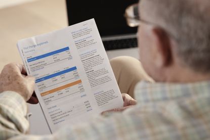 senior man looking at household bill