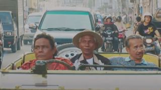 Three men in the front seat of a car in The Act of Killing