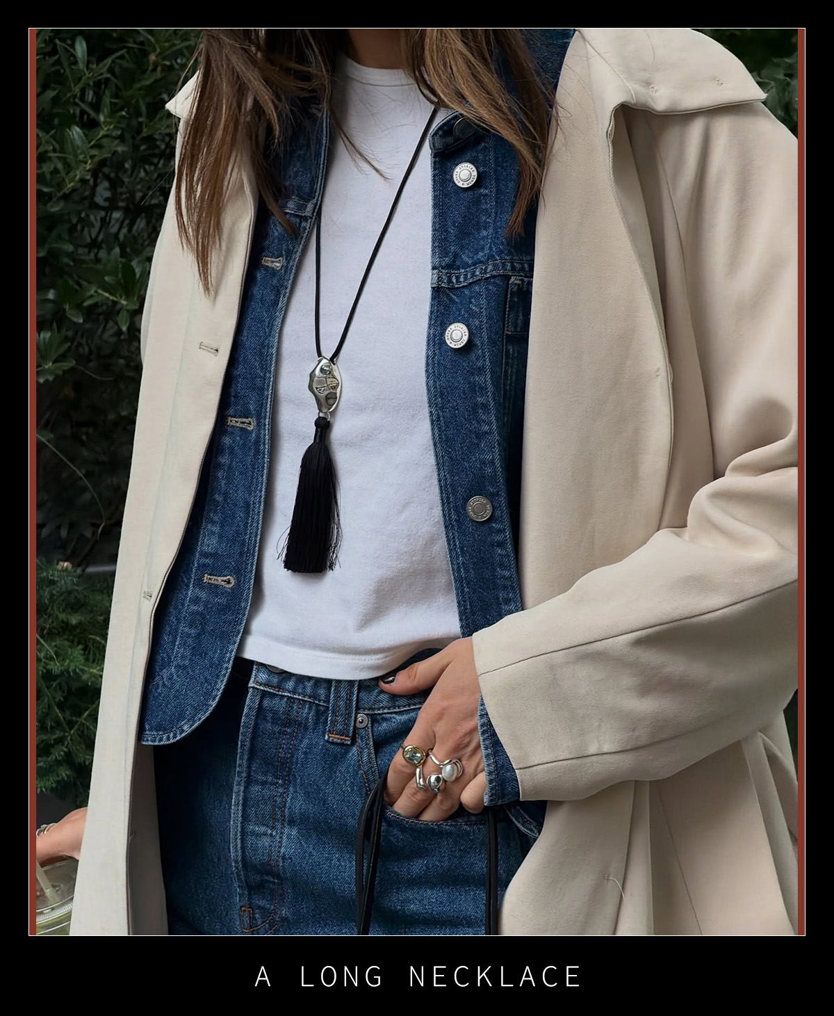 Woman in a denim outfit and a long pendant necklace.