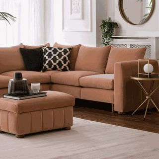 A blush pink corner sofa in a living room