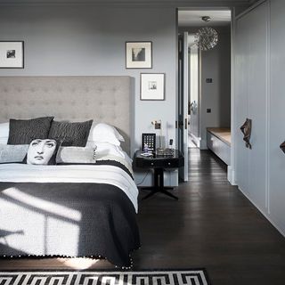 bedroom with white wall bed cushions and bedside table