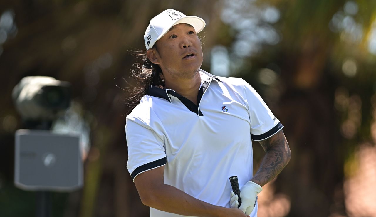 Anthony Kim hits a tee shot and watches the flight of it