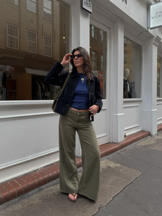 Influencer Francesca Saffari wearing a blue cropped t-shirt, black denim jacket, wide leg jeans and flip flops. 