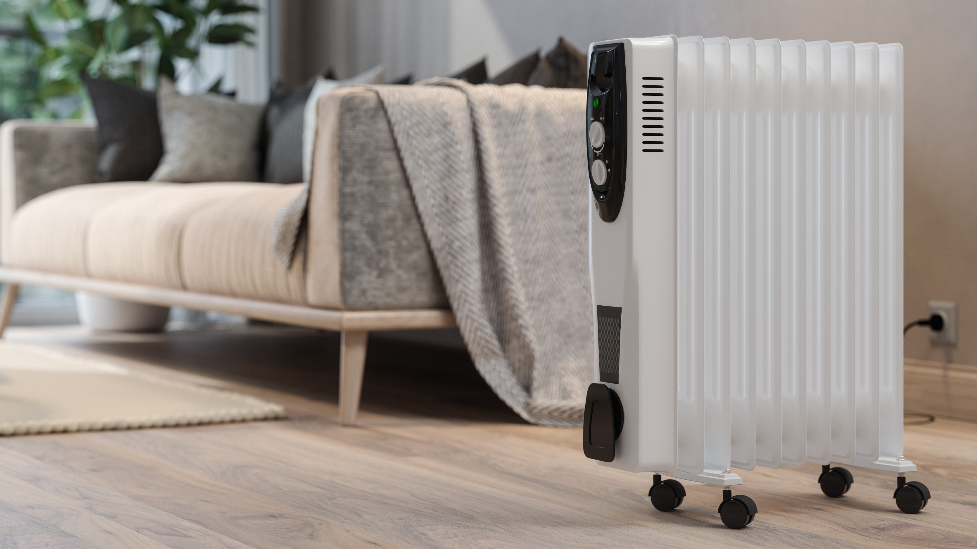 Oil-filled radiator in living room next to a sofa with a blanket over the arm