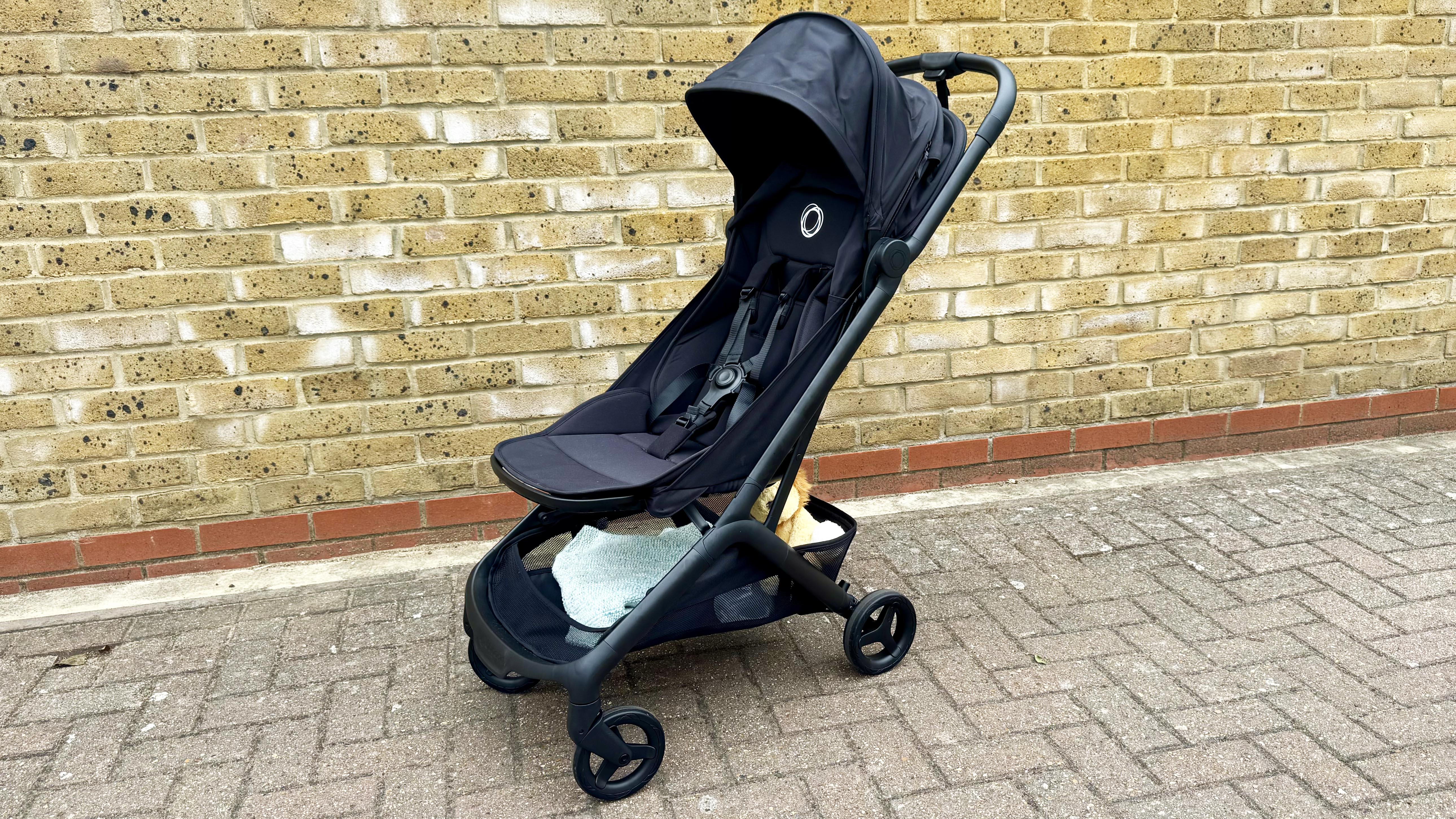 Bugaboo Butterfly 2 stroller unfolded next to a brick wall