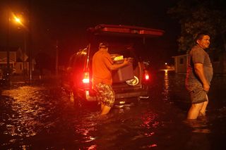People pack their belongings after evacuating their house when the Neuse River went over its banks and flooded their street in New Bern, North Carolina, during Hurricane Florence Sept. 13, 2018.