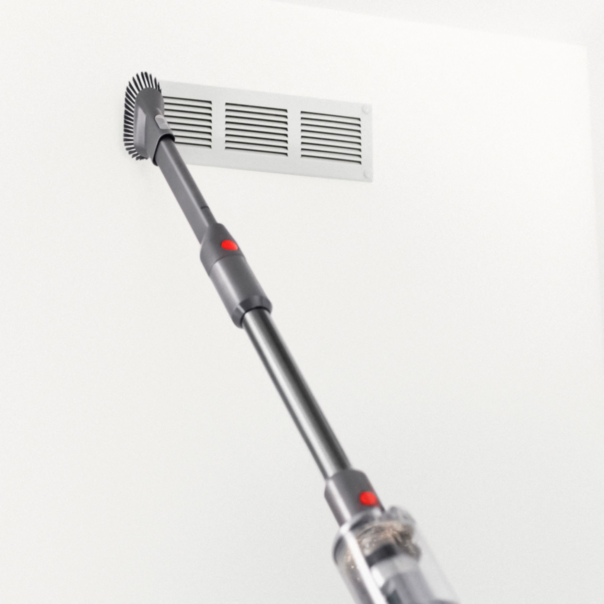 Dyson vacuum cleaning the surface of a vent