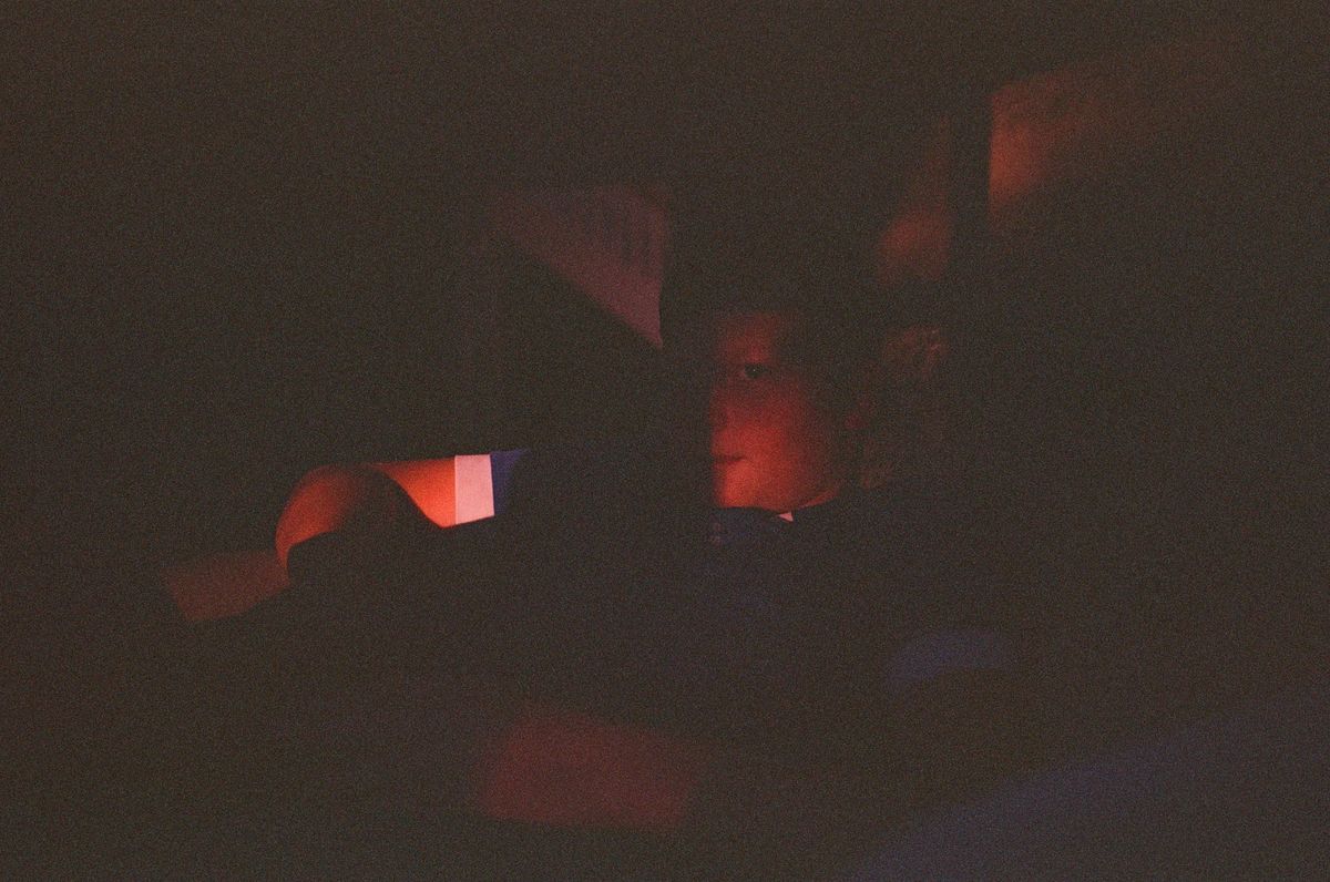 Leica MP color film scan of adolescent boy illuminated a little by last light coming through a window