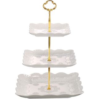 A white porcelain square cake stand with gold metal rod