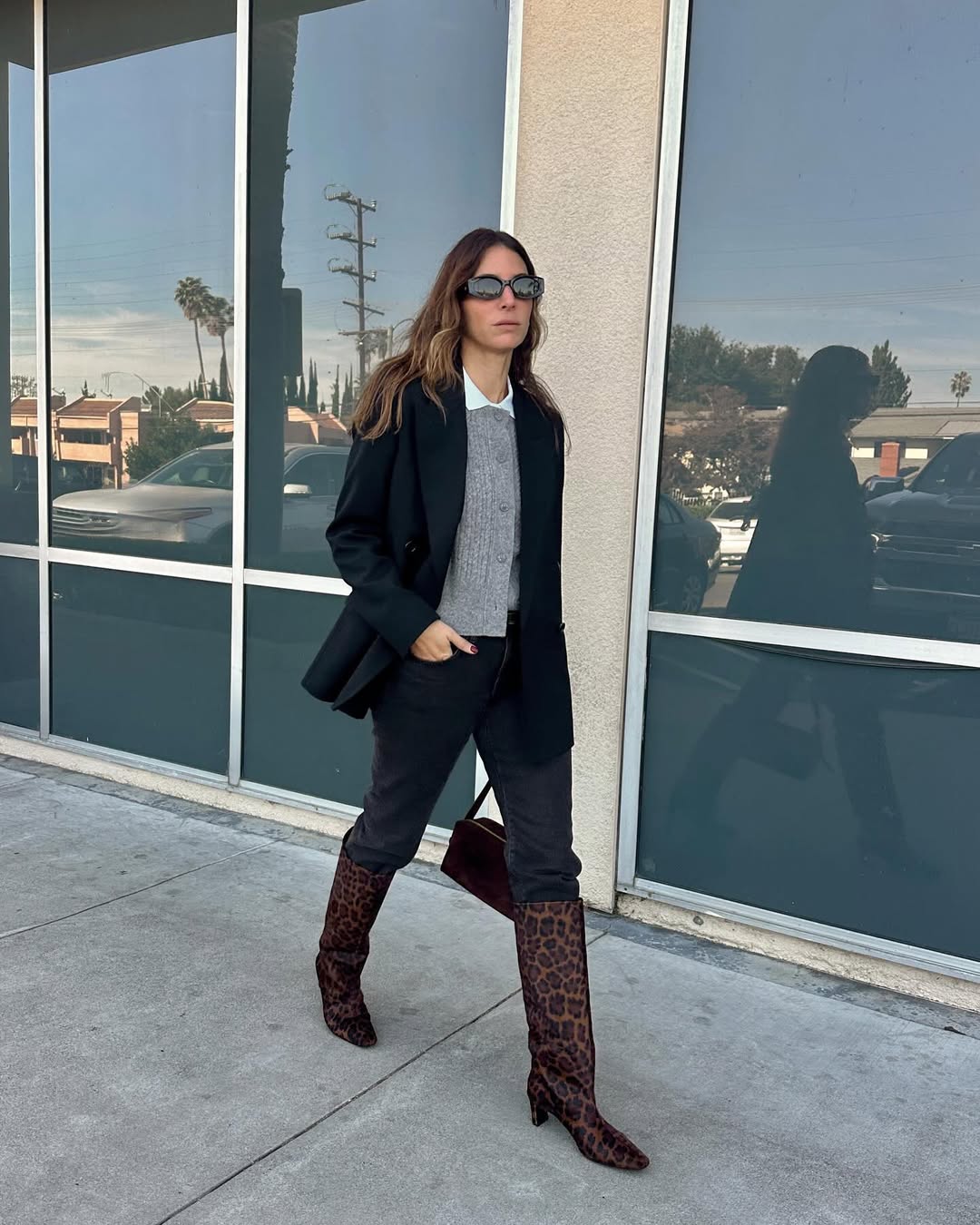 Woman wearing boots tucked into jeans trend fall 2025.