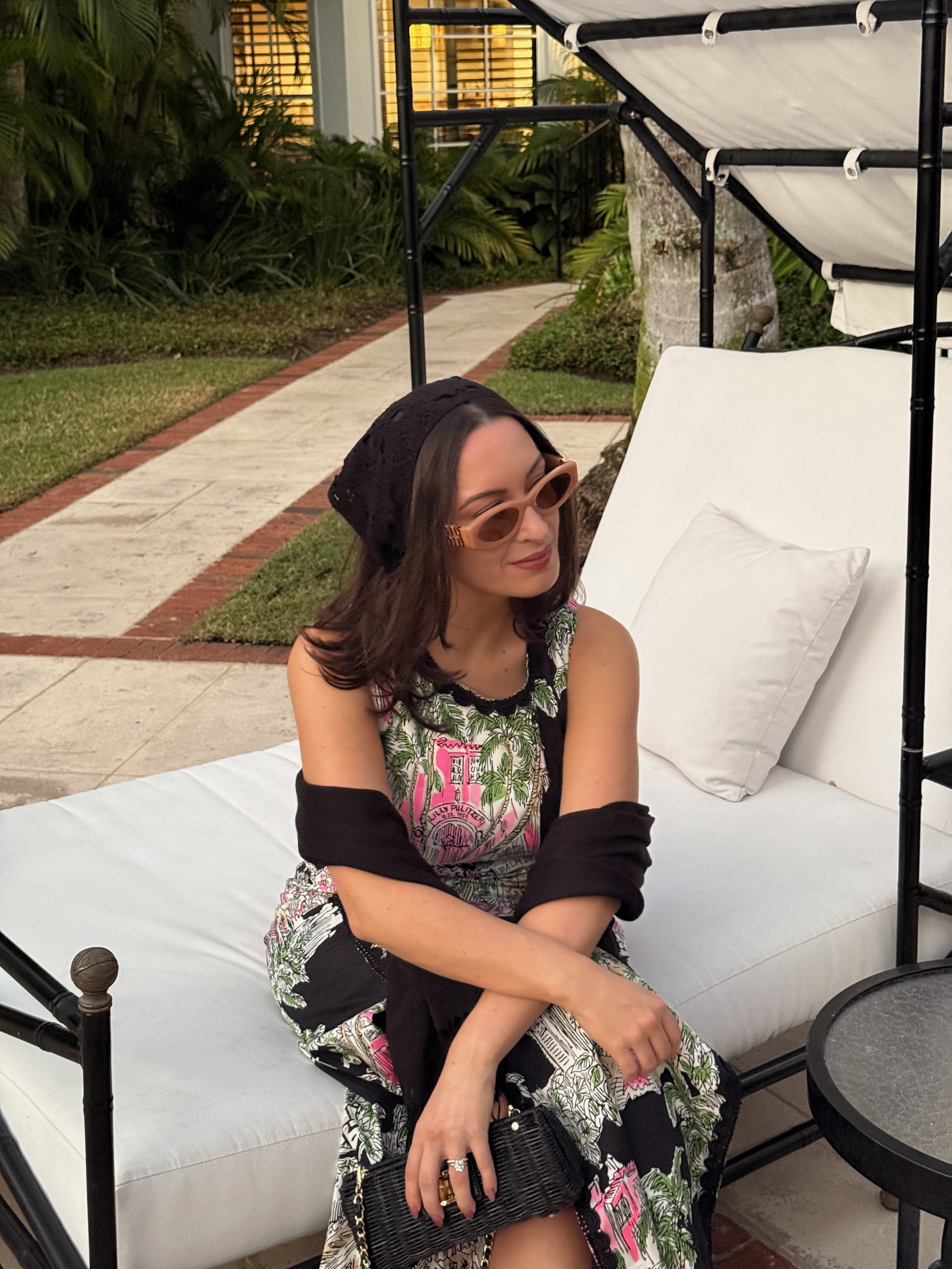 Bella Gerard wearing a headscarf, sunglasses, and a printed dress while on vacation in Florida