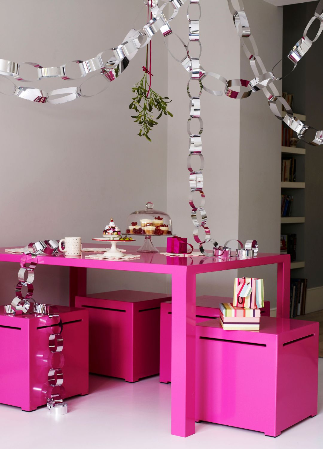 picture of pink dining set with metallic paperrings hanging over it