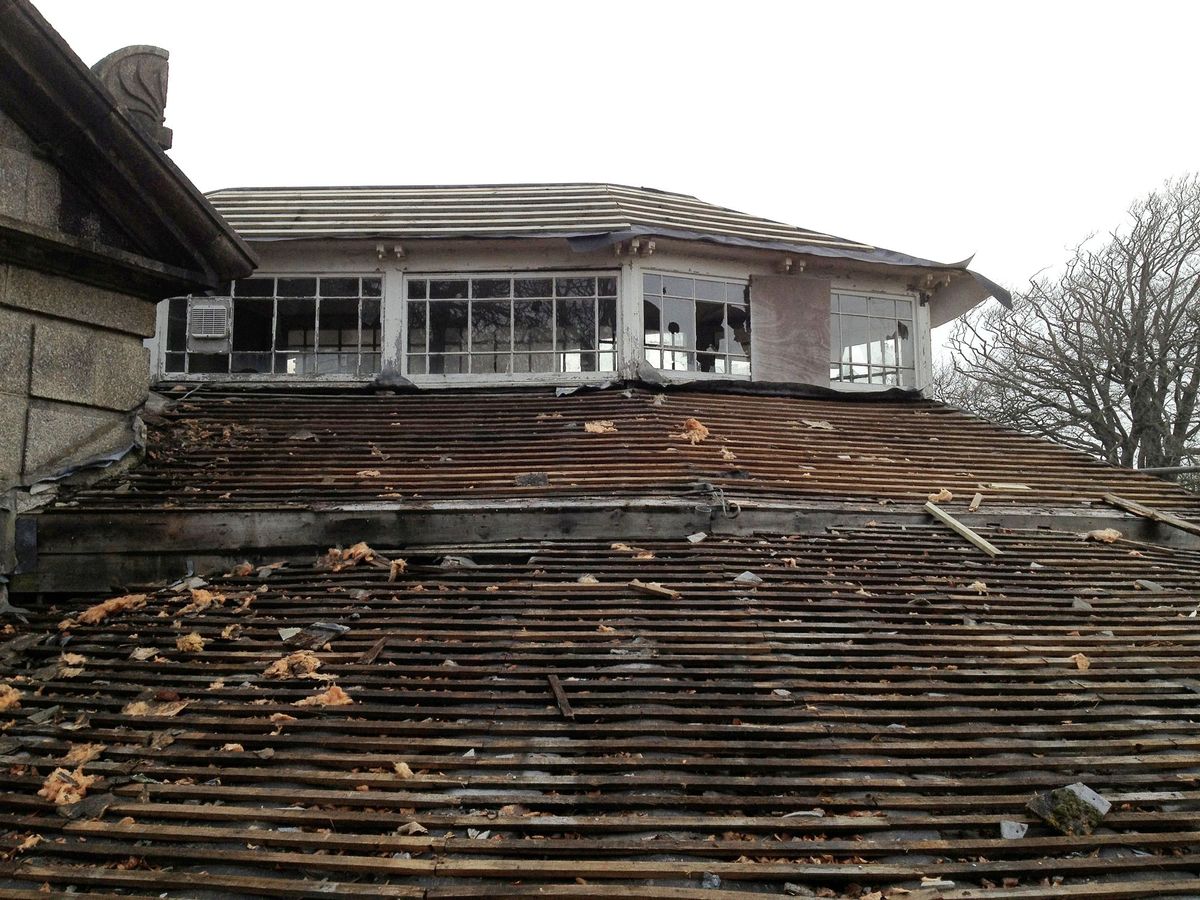 A before image of the roof and roof light with tiles falling off and the wood rotting