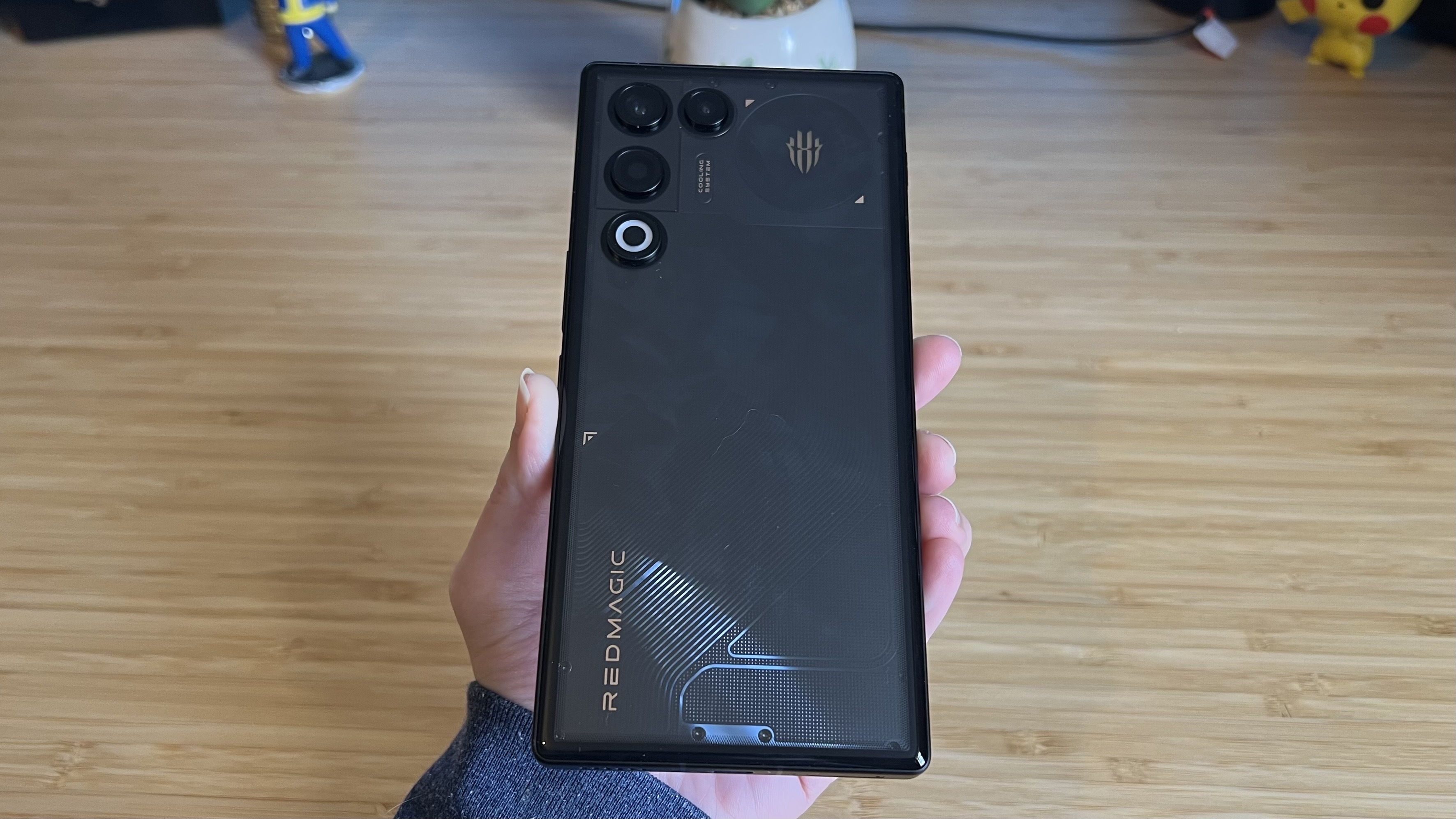 Hand holding RedMagic 11 Air gaming phone showing its back panel design and fingerprints