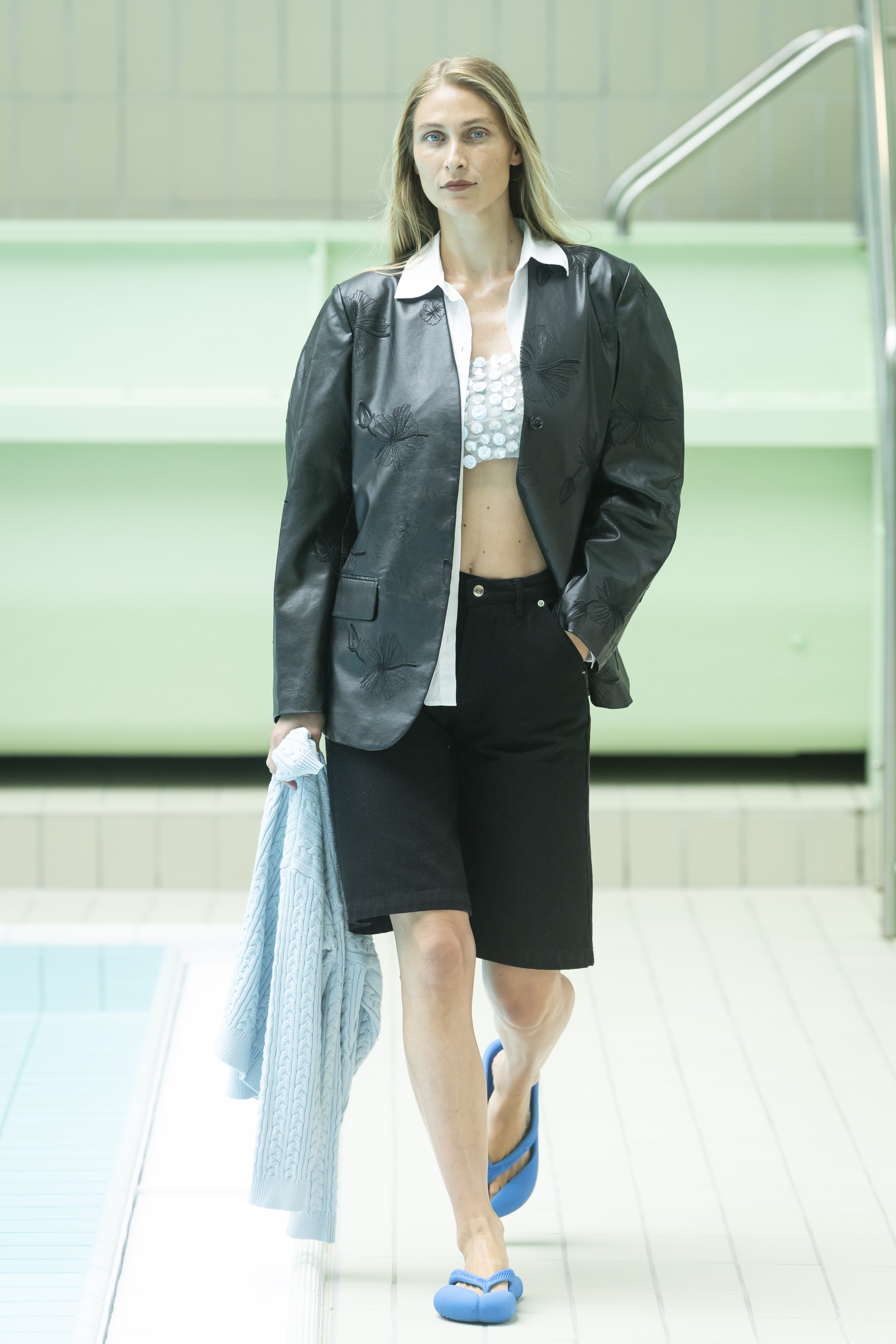 a model wearing bermuda shorts with a tabi inspired flip flop